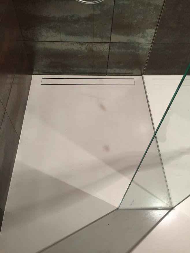 Biela liata podlaha v sprchovom kute